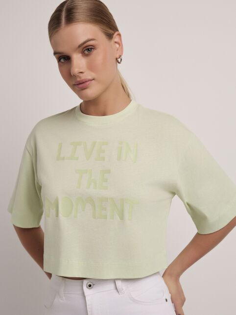 Укороченная футболка из хлопка с печатным рисунком «Live in the moment» LD 2722 Укороченная футболка из хлопка с печатным рисунком «Live in the moment» LD 2722 - купить в интернет-магазине Conte